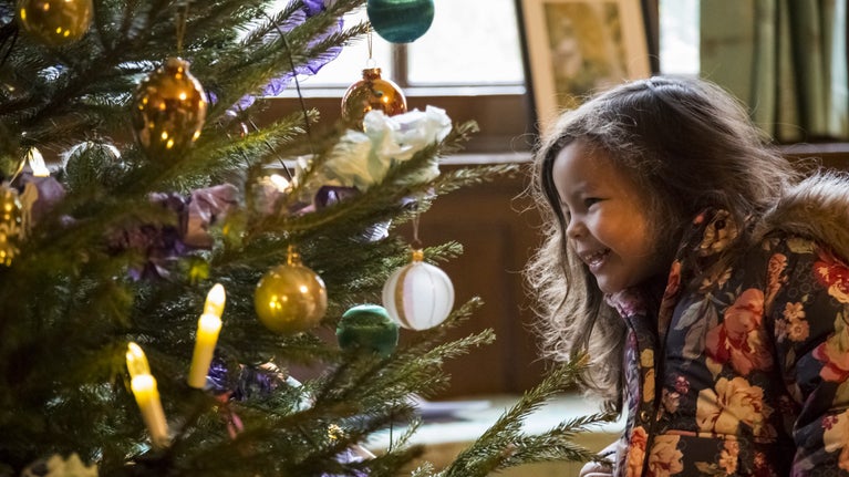 A young girl enjoying the Christmas theme at Avebury Manor, Wiltshire